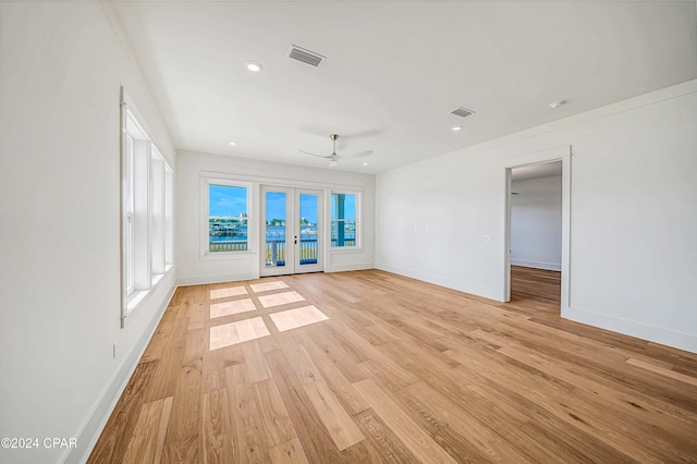 unfurnished living room featuring french doors, light hardwood / wood-style flooring, and ceiling fan