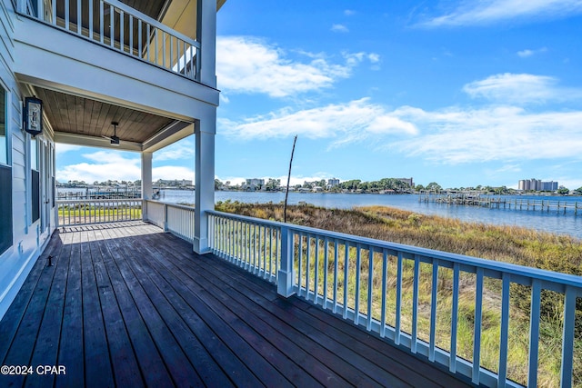 wooden deck featuring a water view and ceiling fan