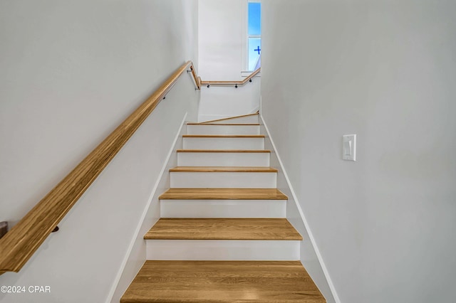 stairs featuring hardwood / wood-style flooring