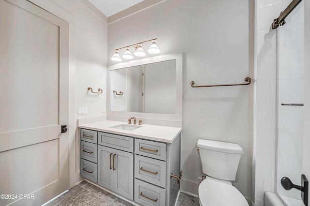 bathroom with vanity, tiled shower, and toilet