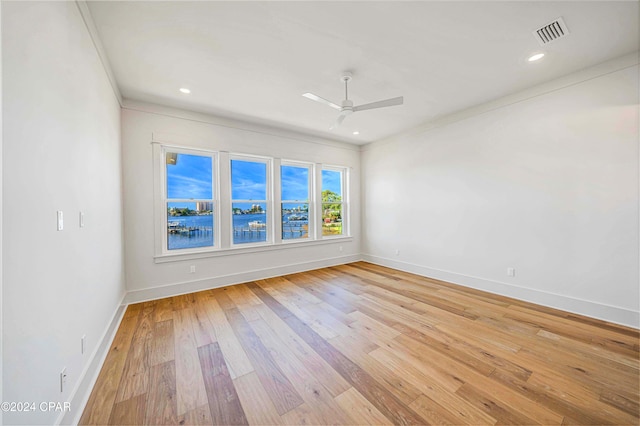 spare room featuring ornamental molding, light wood-type flooring, and ceiling fan