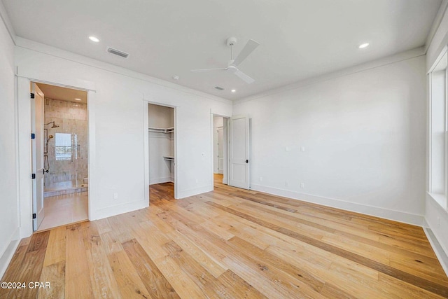 unfurnished bedroom with a walk in closet, ceiling fan, light hardwood / wood-style flooring, a closet, and ensuite bath