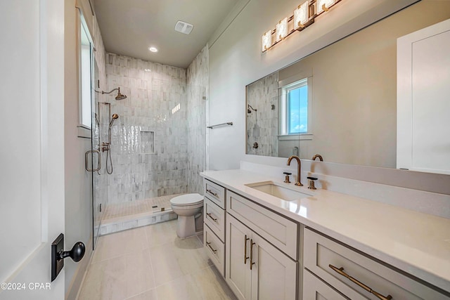 bathroom featuring vanity, toilet, tile patterned floors, and a shower with shower door