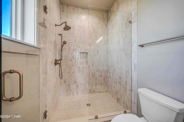 bathroom featuring toilet and an enclosed shower