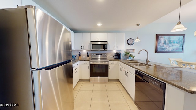 kitchen with light tile patterned floors, white cabinets, a peninsula, stainless steel appliances, and a sink