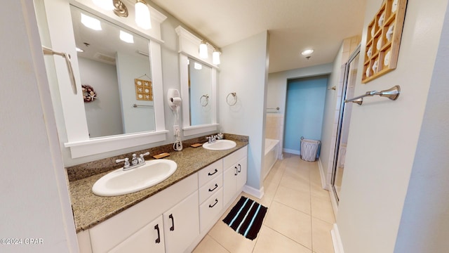 bathroom featuring double vanity, a sink, a shower stall, and tile patterned floors