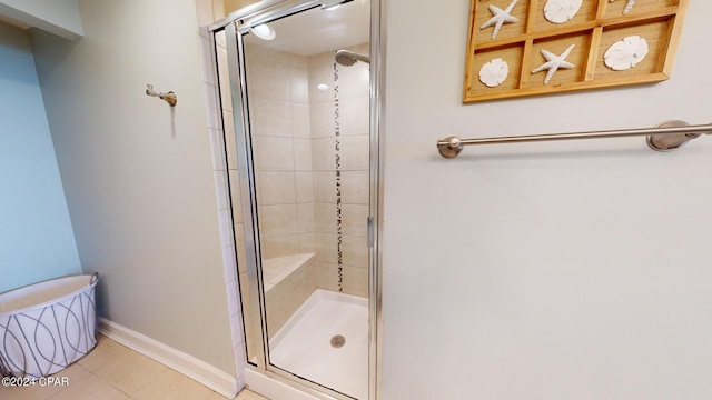 full bath with a stall shower, tile patterned flooring, and baseboards