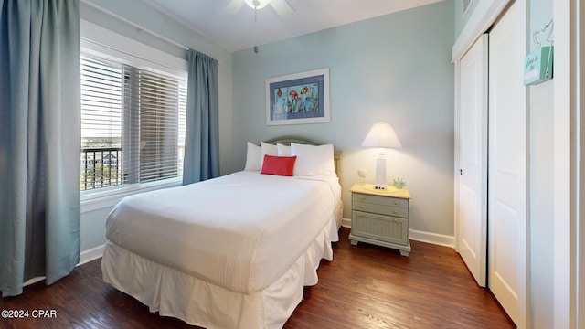 bedroom with dark wood-style flooring, a closet, a ceiling fan, and baseboards