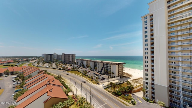 drone / aerial view featuring a view of city, a water view, and a beach view