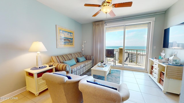 living room with a water view, light tile patterned floors, baseboards, and a ceiling fan