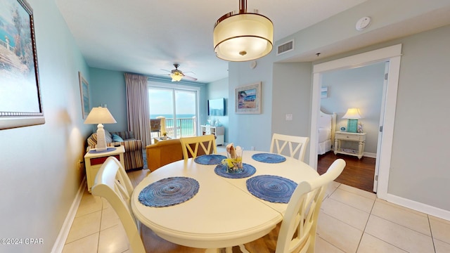 dining room with light tile patterned floors, ceiling fan, visible vents, and baseboards