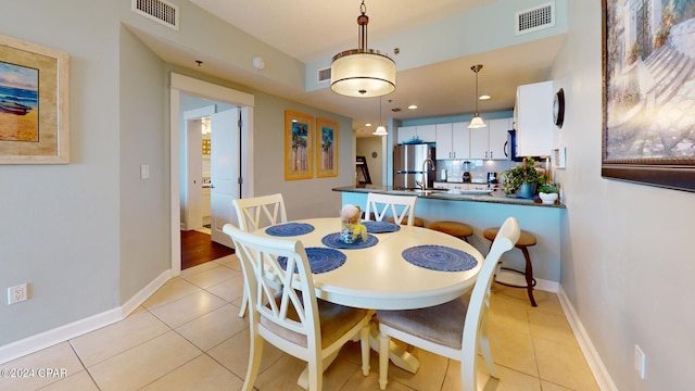 dining space with light tile patterned floors, baseboards, and visible vents