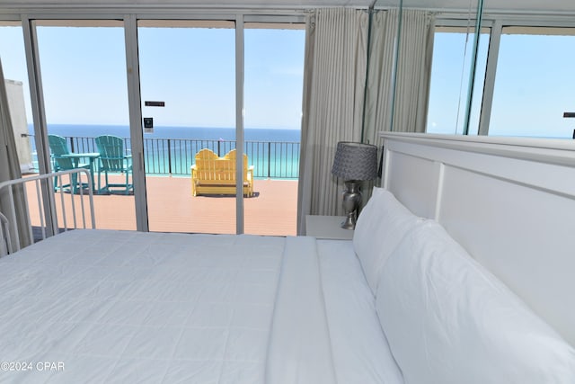 bedroom with multiple windows and a water view