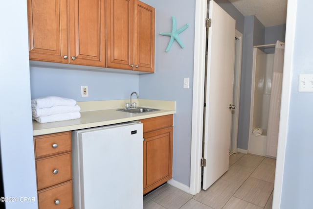 kitchen featuring white refrigerator and sink