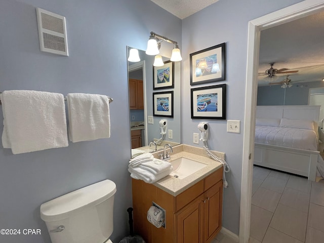 bathroom featuring ceiling fan, toilet, tile patterned floors, vanity, and a textured ceiling