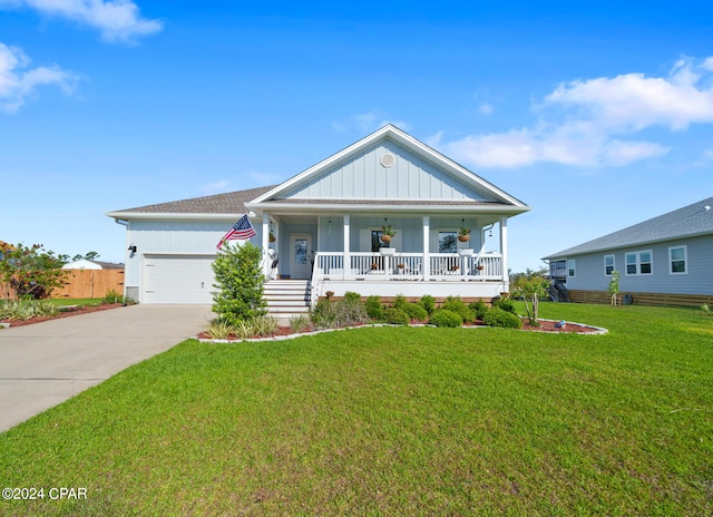 view of front of property featuring a garage, a front yard, and covered porch