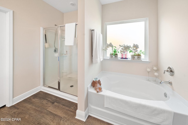 bathroom featuring wood-type flooring and shower with separate bathtub