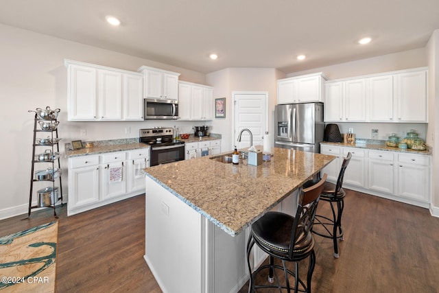 kitchen with dark hardwood / wood-style flooring, white cabinetry, an island with sink, appliances with stainless steel finishes, and sink