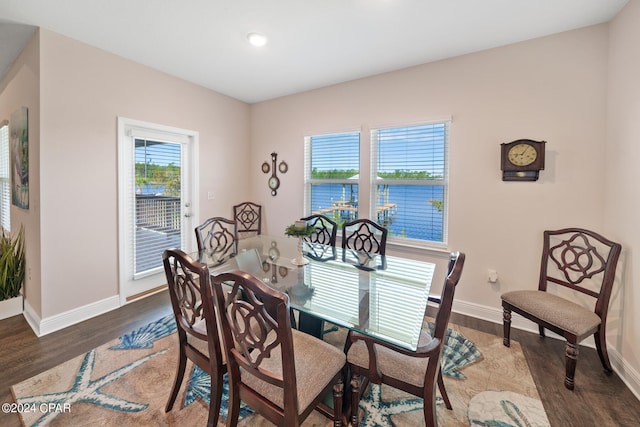 dining room featuring plenty of natural light, a water view, and dark hardwood / wood-style flooring