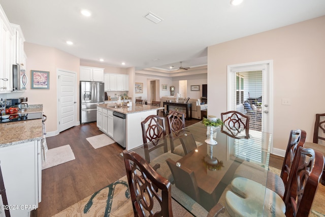 dining area with plenty of natural light, sink, dark hardwood / wood-style flooring, and ceiling fan