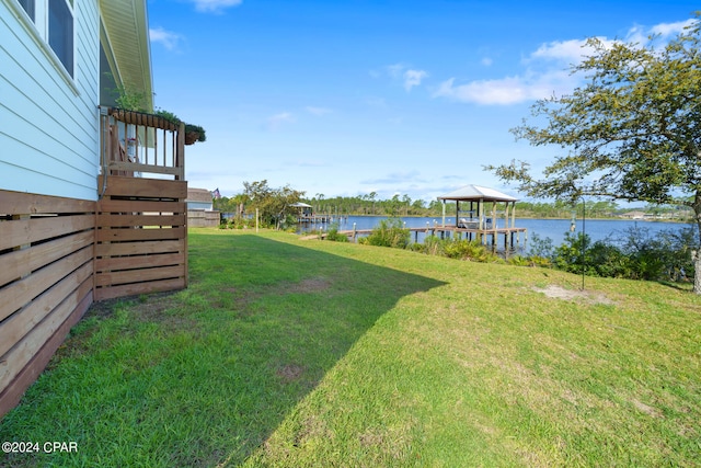 view of yard with a water view and a dock