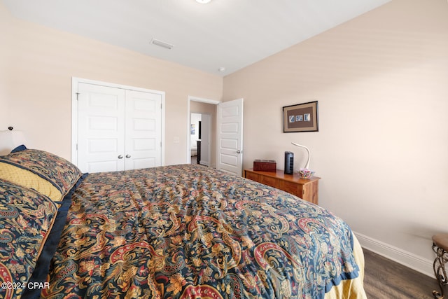 bedroom with a closet and dark hardwood / wood-style flooring