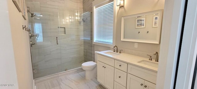 bathroom featuring vanity, toilet, and a shower with door