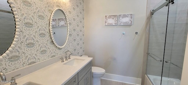 full bathroom with vanity, bath / shower combo with glass door, and toilet