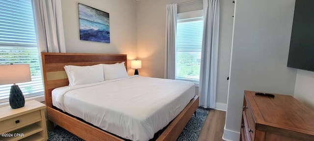 bedroom with dark hardwood / wood-style flooring