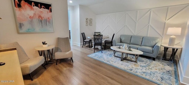 living room featuring wood-type flooring and vaulted ceiling