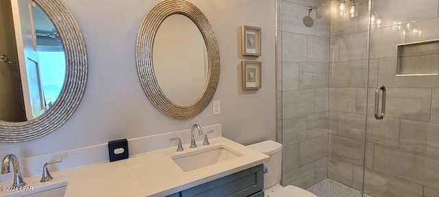 bathroom with a shower with door, vanity, and toilet