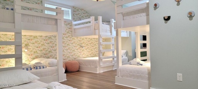 bedroom with wood-type flooring and a towering ceiling