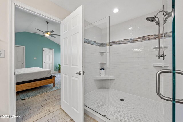 bathroom with ceiling fan, walk in shower, and vaulted ceiling