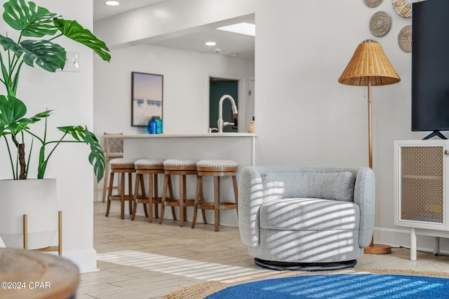 living area with sink and light hardwood / wood-style floors