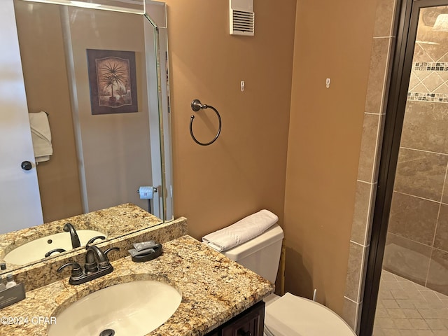 bathroom featuring vanity, toilet, and a shower with shower door