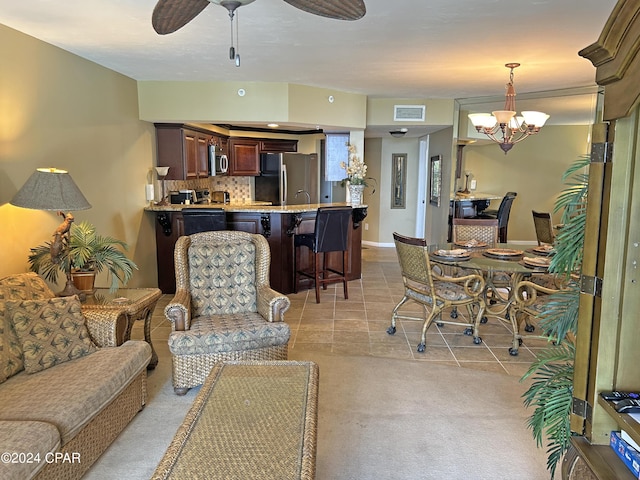 tiled living room featuring ceiling fan with notable chandelier