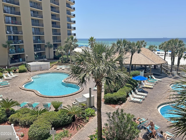 view of pool with a patio and a water view