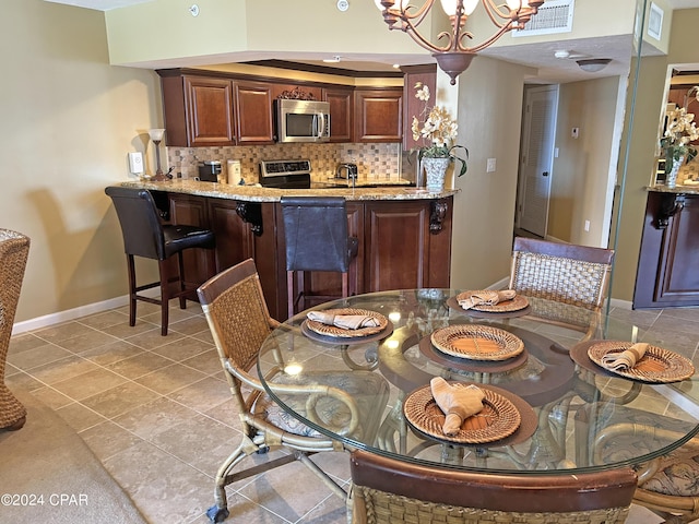 tiled dining area featuring an inviting chandelier