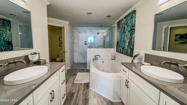 full bathroom featuring separate shower and tub, large vanity, hardwood / wood-style floors, crown molding, and toilet