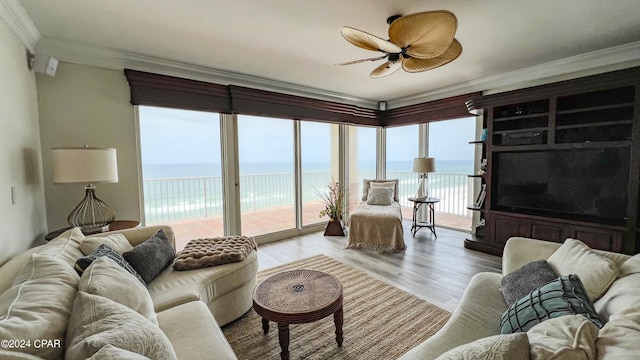 living room with crown molding, ceiling fan, hardwood / wood-style floors, and a water view