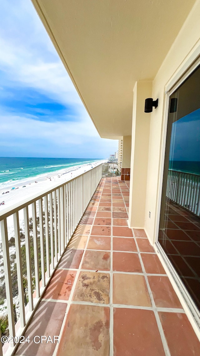 balcony with a water view and a beach view