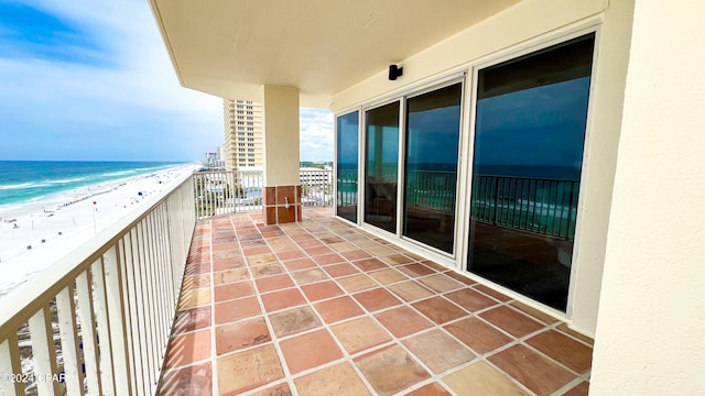 balcony featuring a water view and a view of the beach