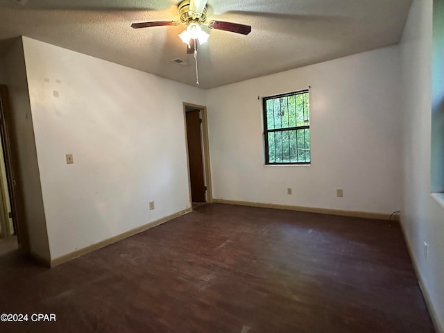 unfurnished room with dark hardwood / wood-style flooring, ceiling fan, and a textured ceiling