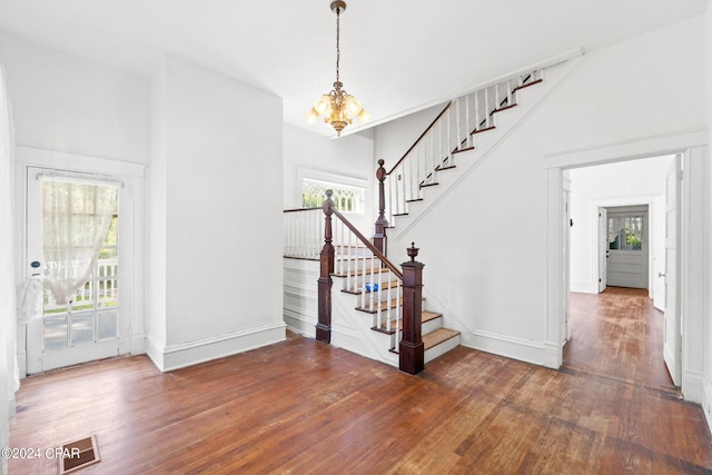 staircase featuring dark hardwood / wood-style floors and a notable chandelier