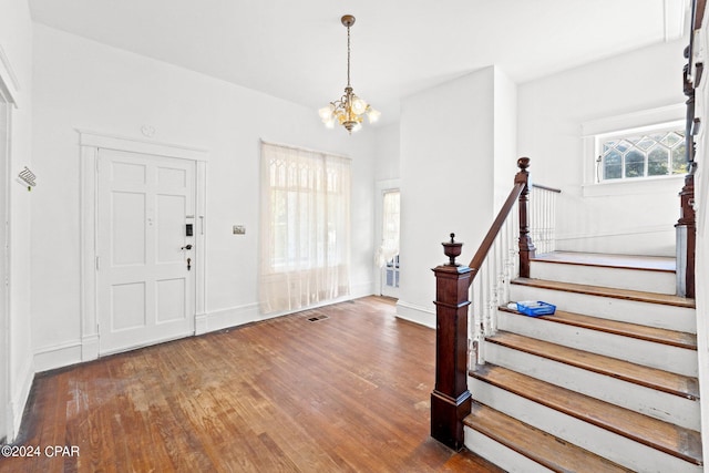 foyer entrance with a notable chandelier and dark wood-type flooring