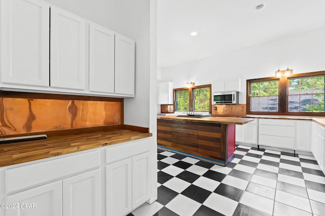 kitchen with a wealth of natural light, wooden counters, and light tile floors