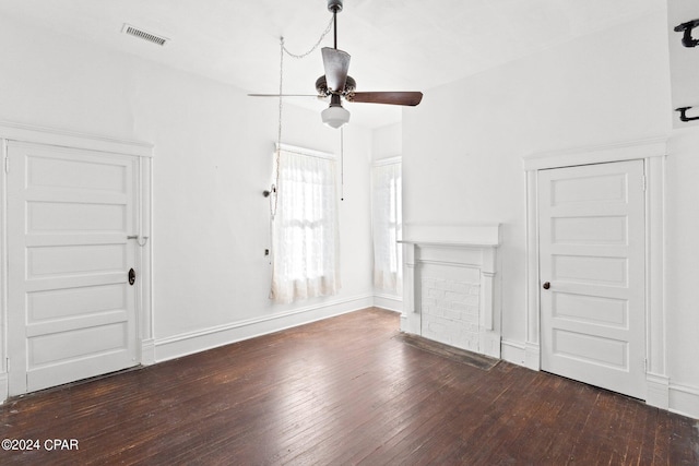 unfurnished living room with dark hardwood / wood-style flooring and ceiling fan