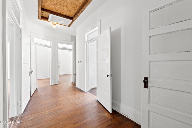 hallway featuring dark hardwood / wood-style flooring and a tray ceiling