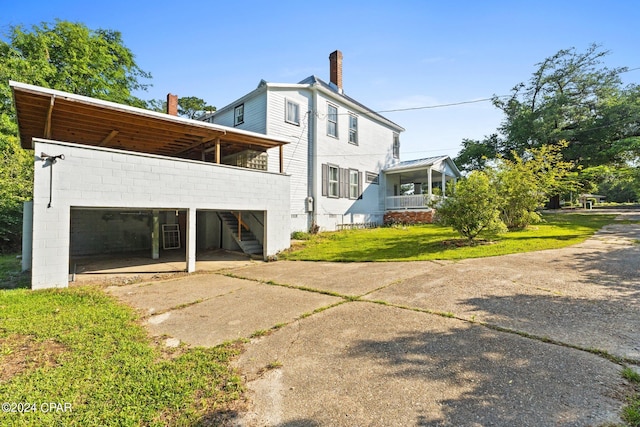 rear view of property featuring a carport and a yard