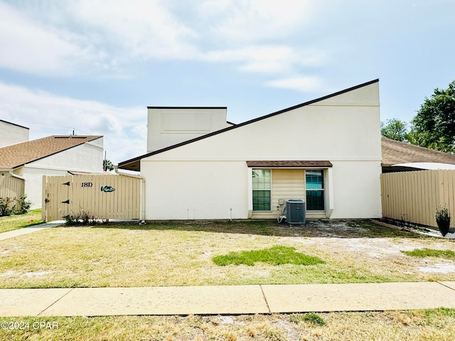 view of front of property with a front lawn and central air condition unit